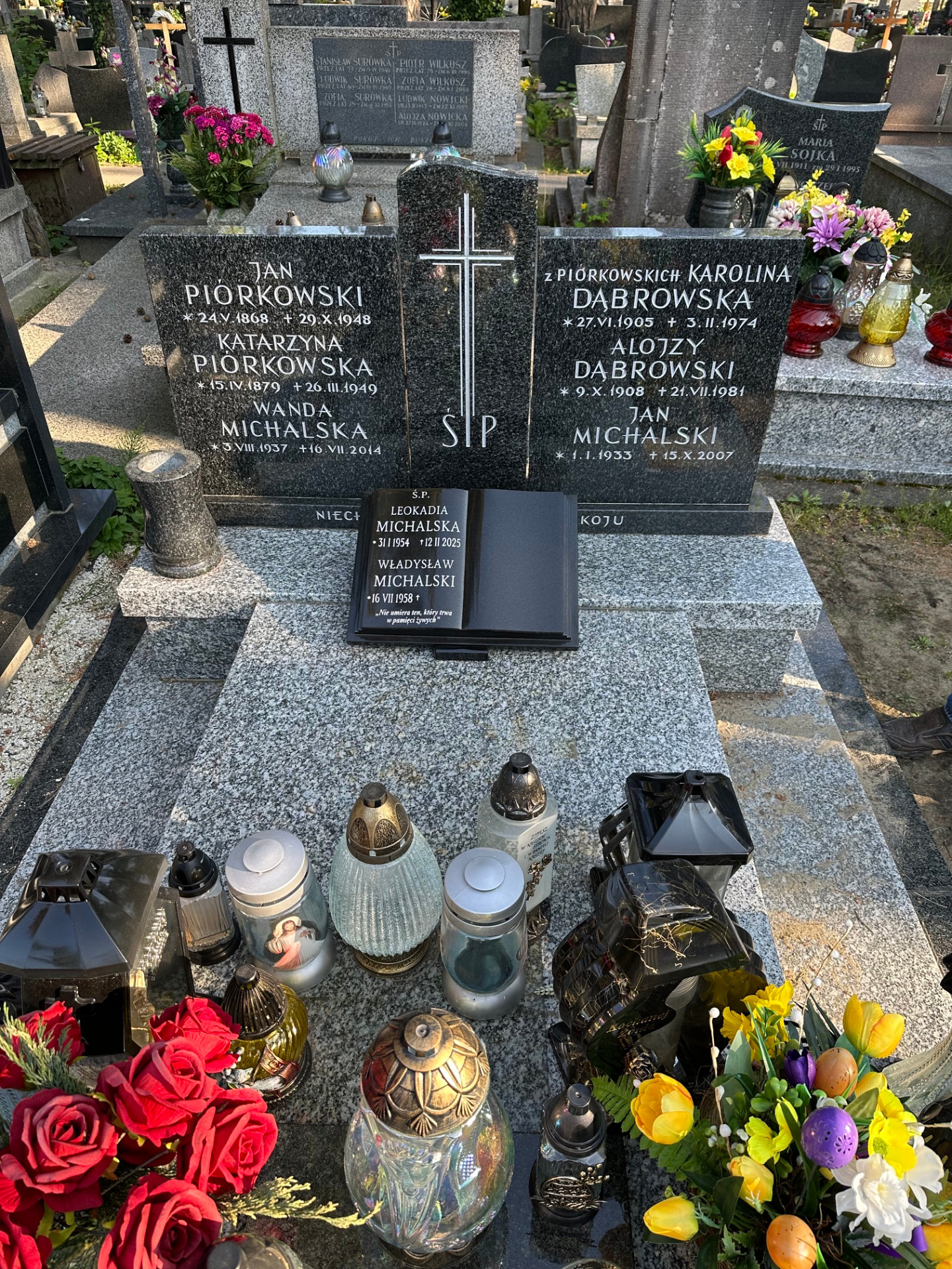 Granitowy nagrobek z krzyżem, napisami i księgą granitową.